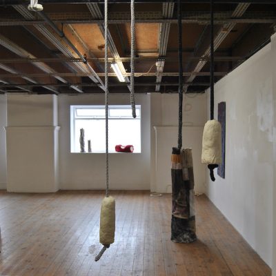 Installation view - (windowsill) Soap Tubes I - III (LB); (corner) Soft Rocks (LB); (left hand wall) Boiler Suit Relief No.4 (SG); (floor) Rag Plinth (Circular) (SG); (foreground) Soap On A Rope (LB)